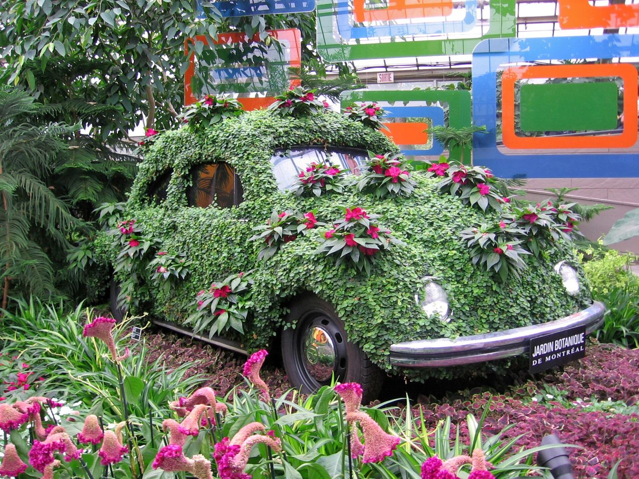A Volkswagen Beetle topiary covered in flowers inside the Montreal Botanical Garden greenhouses