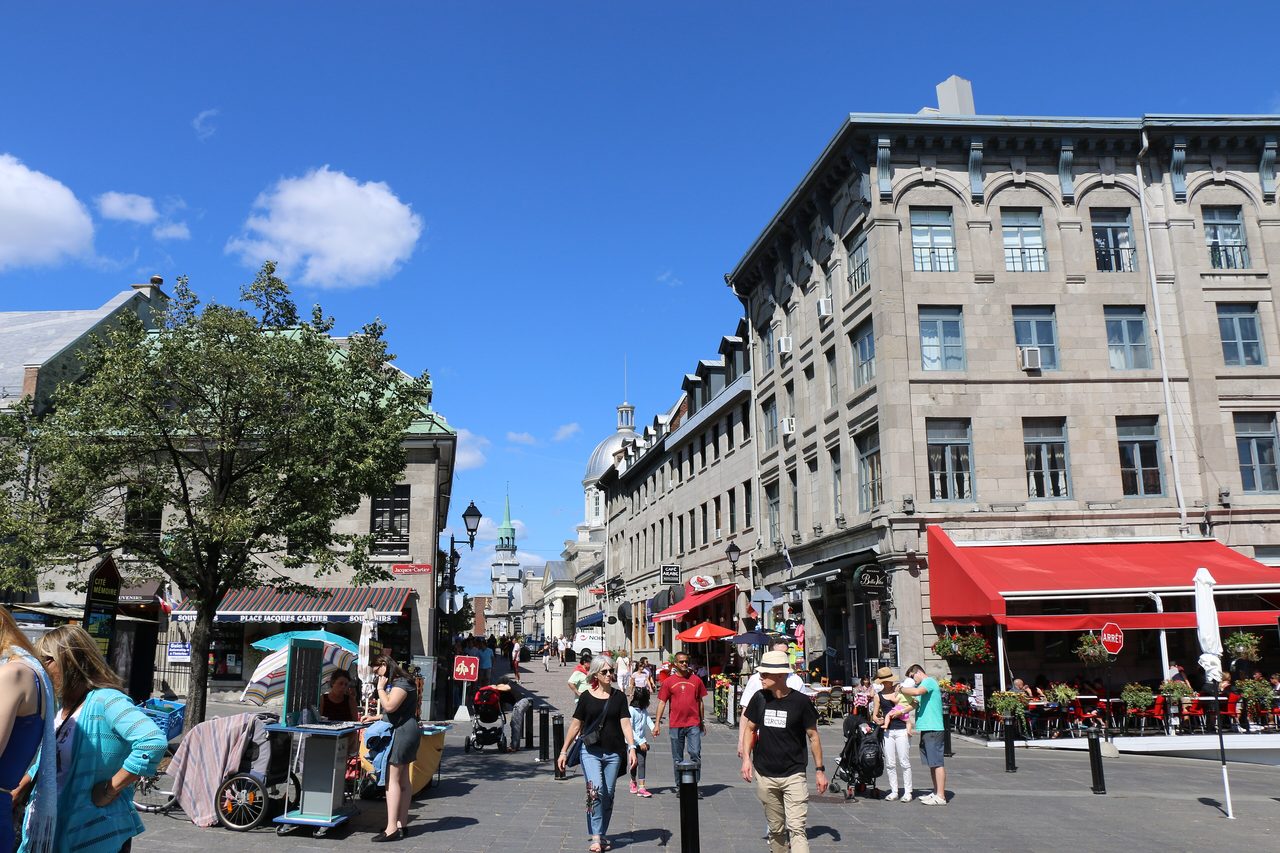 Cobblestone street lined with historic stone buildings in Old Montreal on a sunny day
