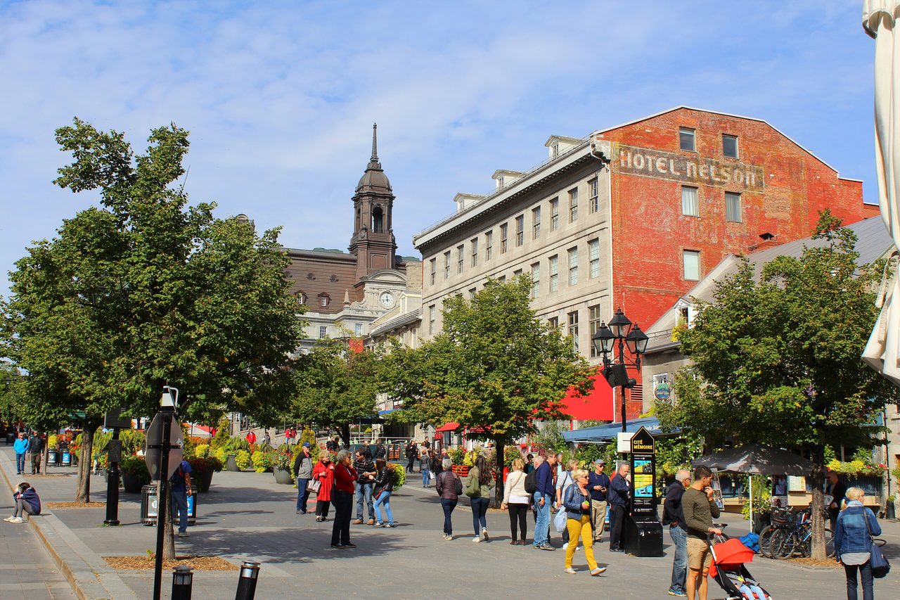 Visitors strolling through the lively Place Jacques-Cartier plaza in Old Montreal