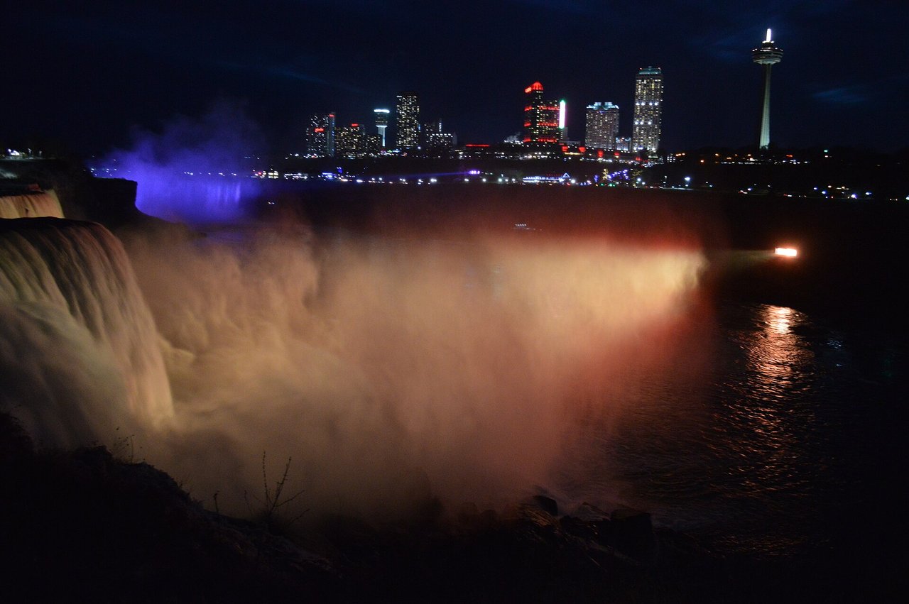 Niagara Falls illuminated in blue and purple lights at night