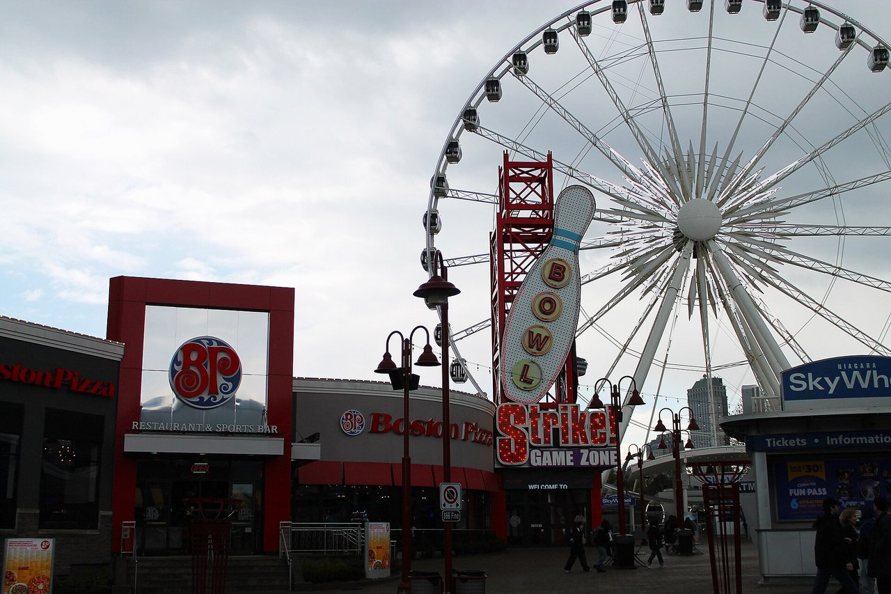 Clifton Hill street with neon signs and the SkyWheel in Niagara Falls, Ontario