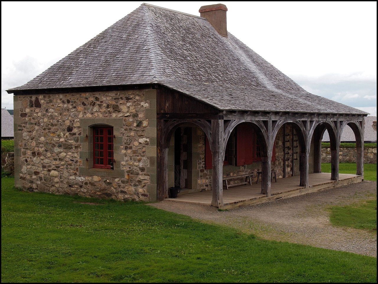 Reconstructed 18th-century buildings inside the Fortress of Louisbourg under a wide Atlantic sky
