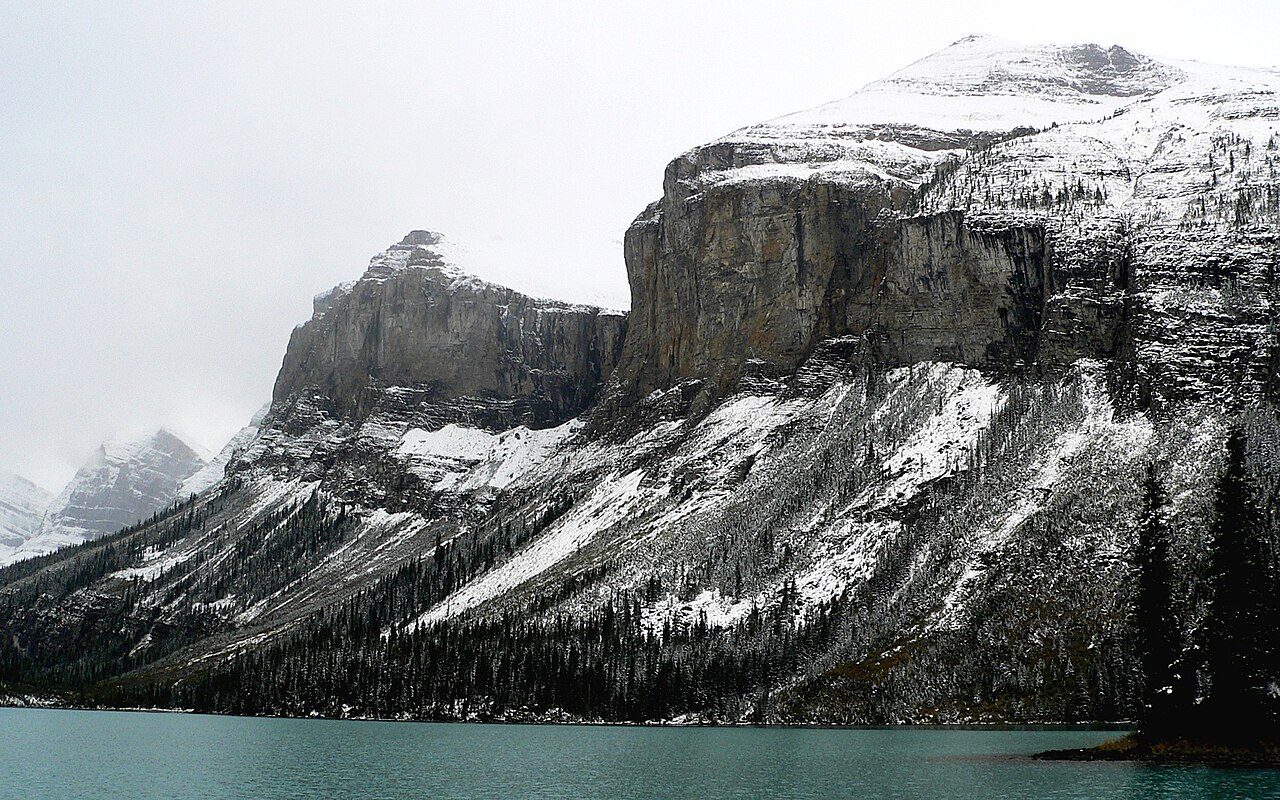 Snow-dusted peaks towering over the turquoise water of Maligne Lake in Jasper National Park
