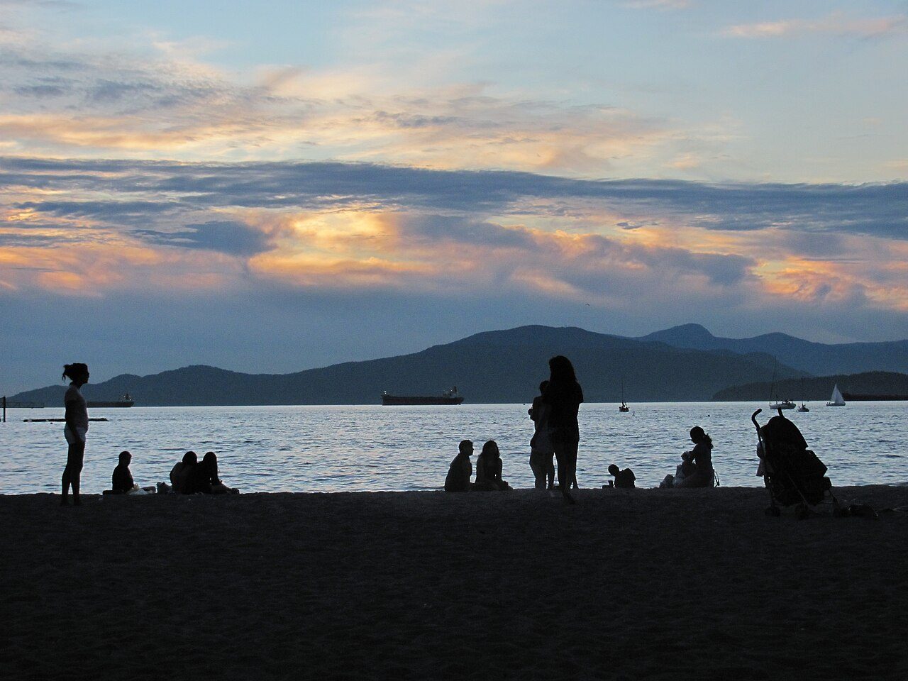 Sunset over Kits Beach with crowds on the sand