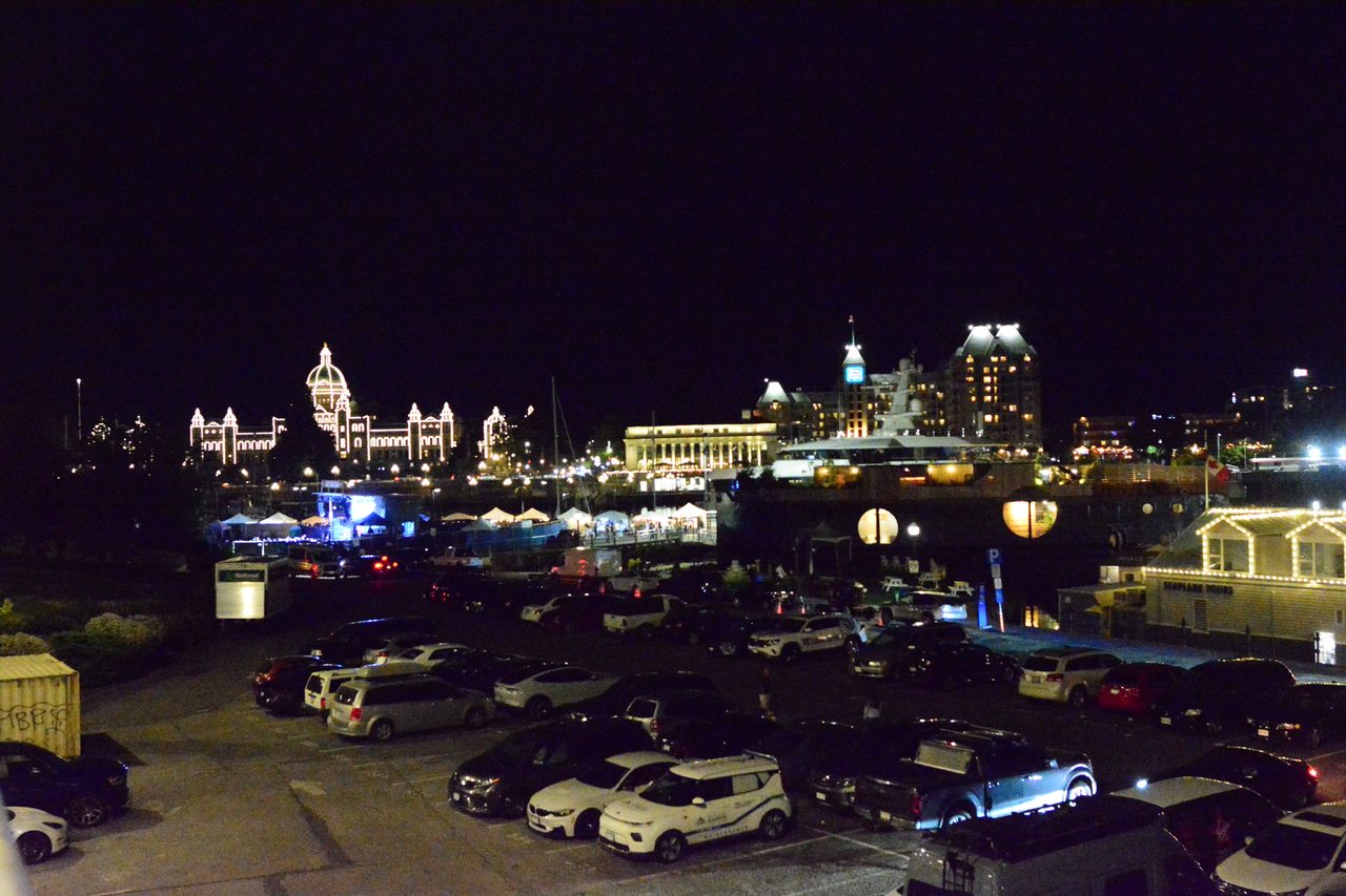 British Columbia Parliament Buildings glowing at night across Victoria's Inner Harbour