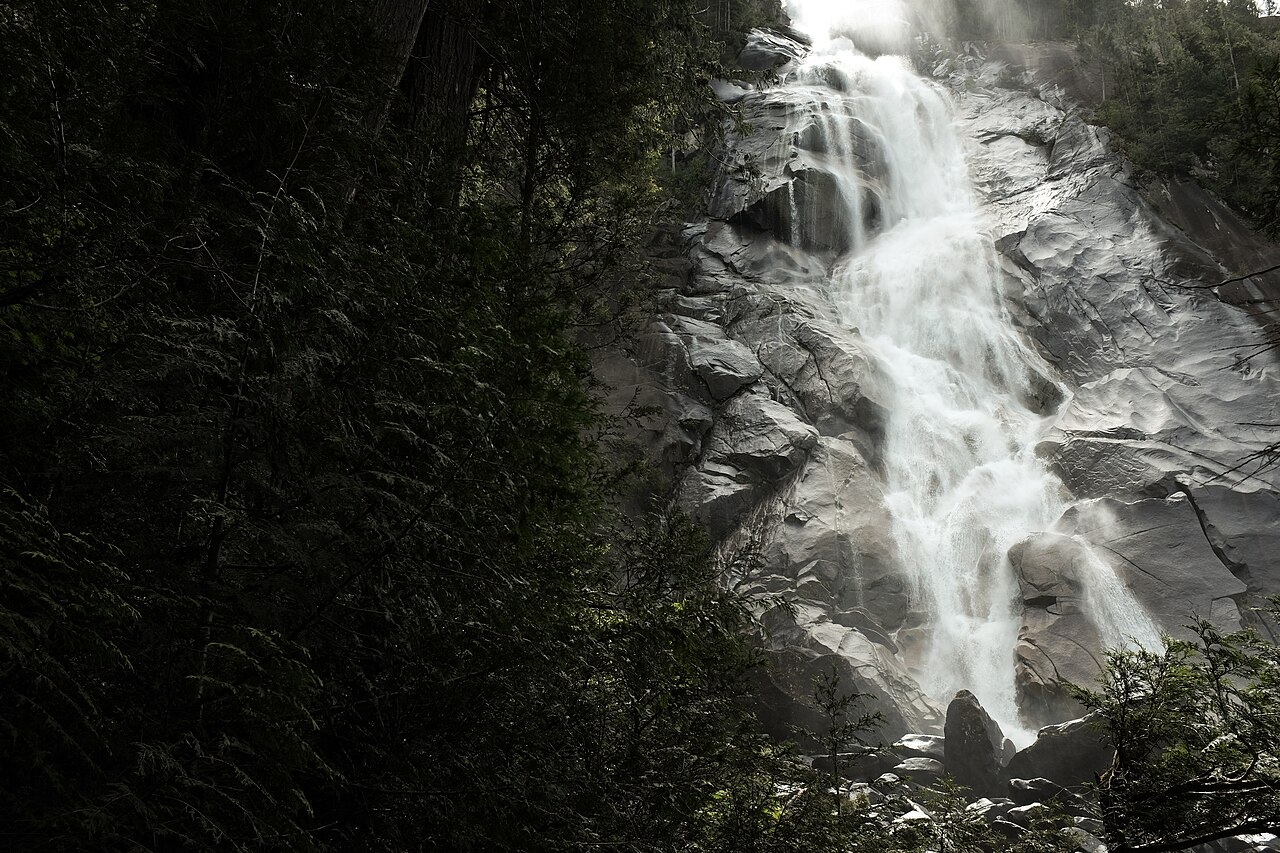 Shannon Falls cascading down a rocky cliff face surrounded by forest near Squamish